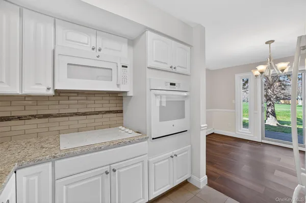 a kitchen with stainless steel appliances granite countertop a sink a stove and cabinets