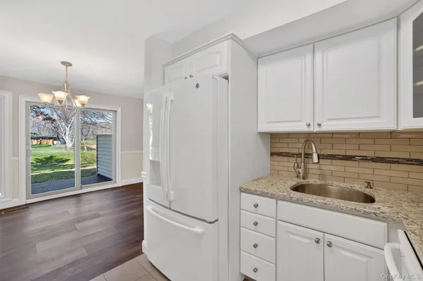 a kitchen with appliances cabinets and a wooden floor