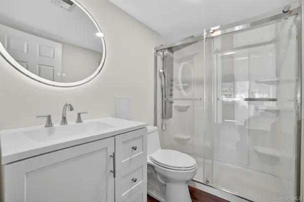 a bathroom with a sink a toilet and shower