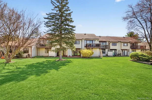 a view of a house with a big yard and large trees