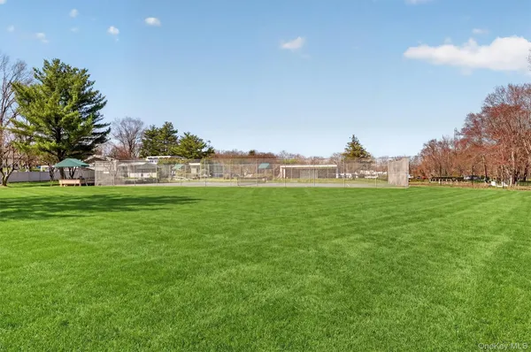 a view of green field with house in background