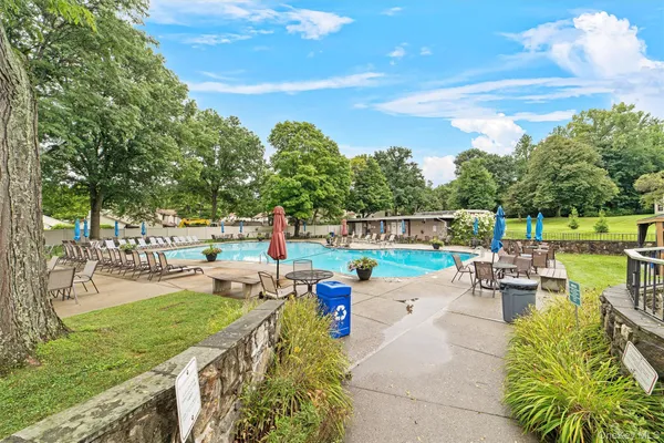 a view of a swimming pool with a patio and a yard