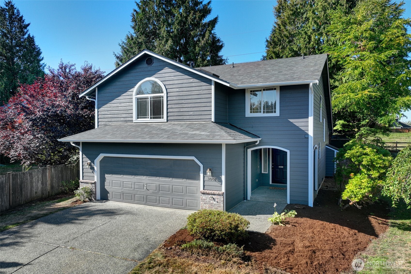 3002 200th Street Southeast Bothell, WA 98012 - Photo 2 of 34 a front view of a house with a yard and garage