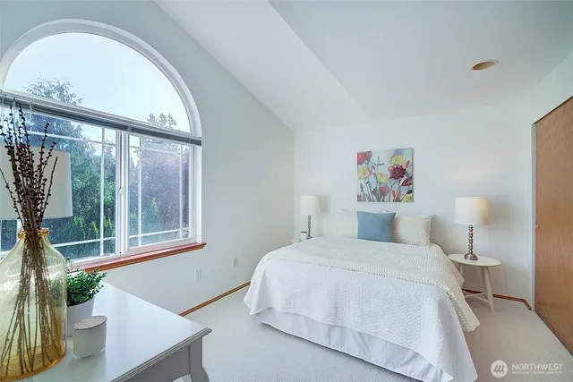 a bedroom with a bed and a large window