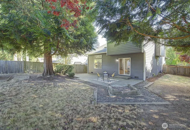 a view of a house with backyard and a tree