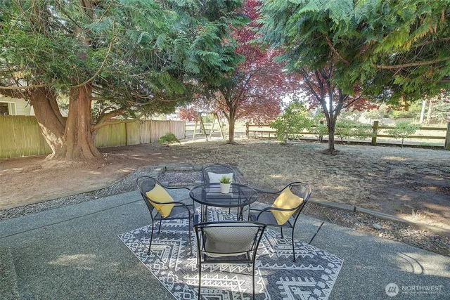 a backyard of a house with table and chairs