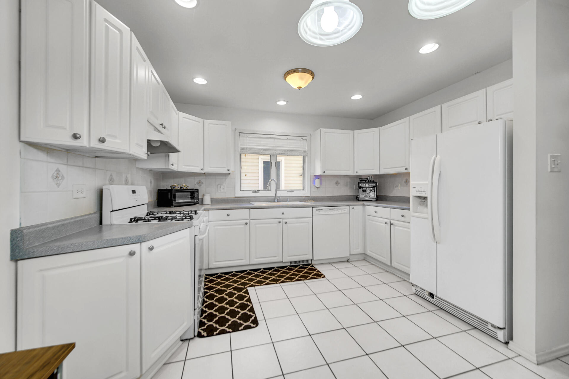 9993 Hunters Run St. John, IN 46373 - Photo 15 of 28 a kitchen with white cabinets a sink and white appliances