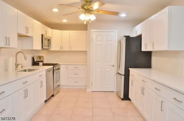 a kitchen with white cabinets and refrigerator