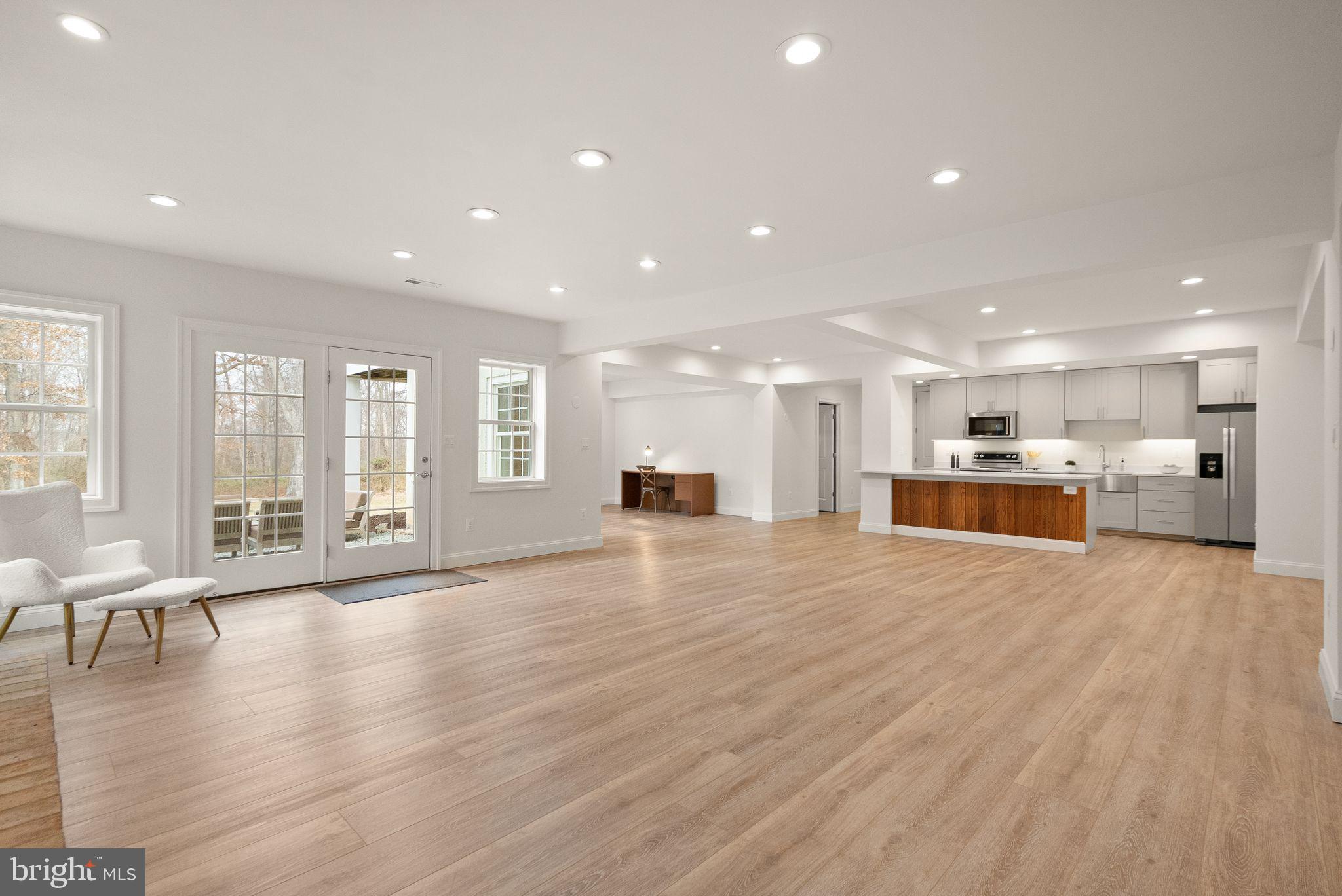 24974 First Harvest Court Aldie, VA 20105 - Photo 89 of 143 a view of an empty room with wooden floor and a kitchen