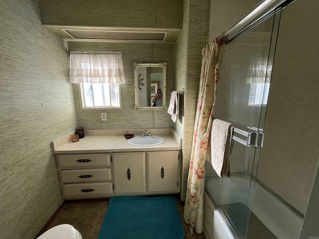 1810 Hillsdale Road, Unit 99 El Cajon, CA 92019 - Photo 11 of 15 a bathroom with a double vanity sink mirror and shower