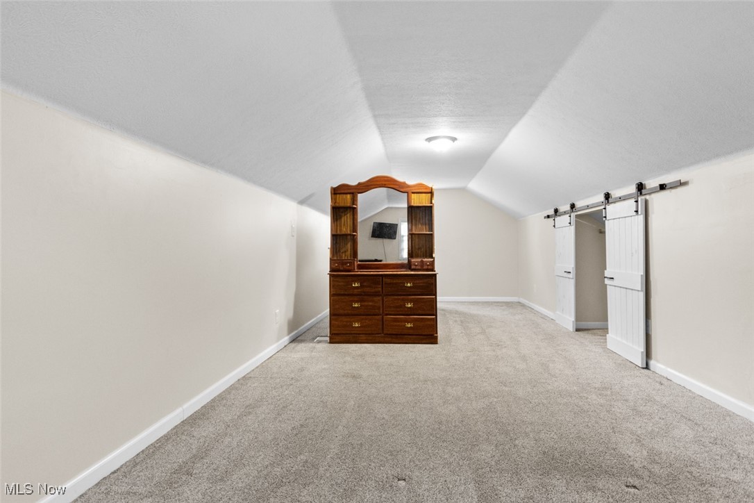 1824 Amherst Road Northeast Massillon, OH 44646 - Photo 23 of 34 featuring carpet floors, vaulted ceiling, and a barn door