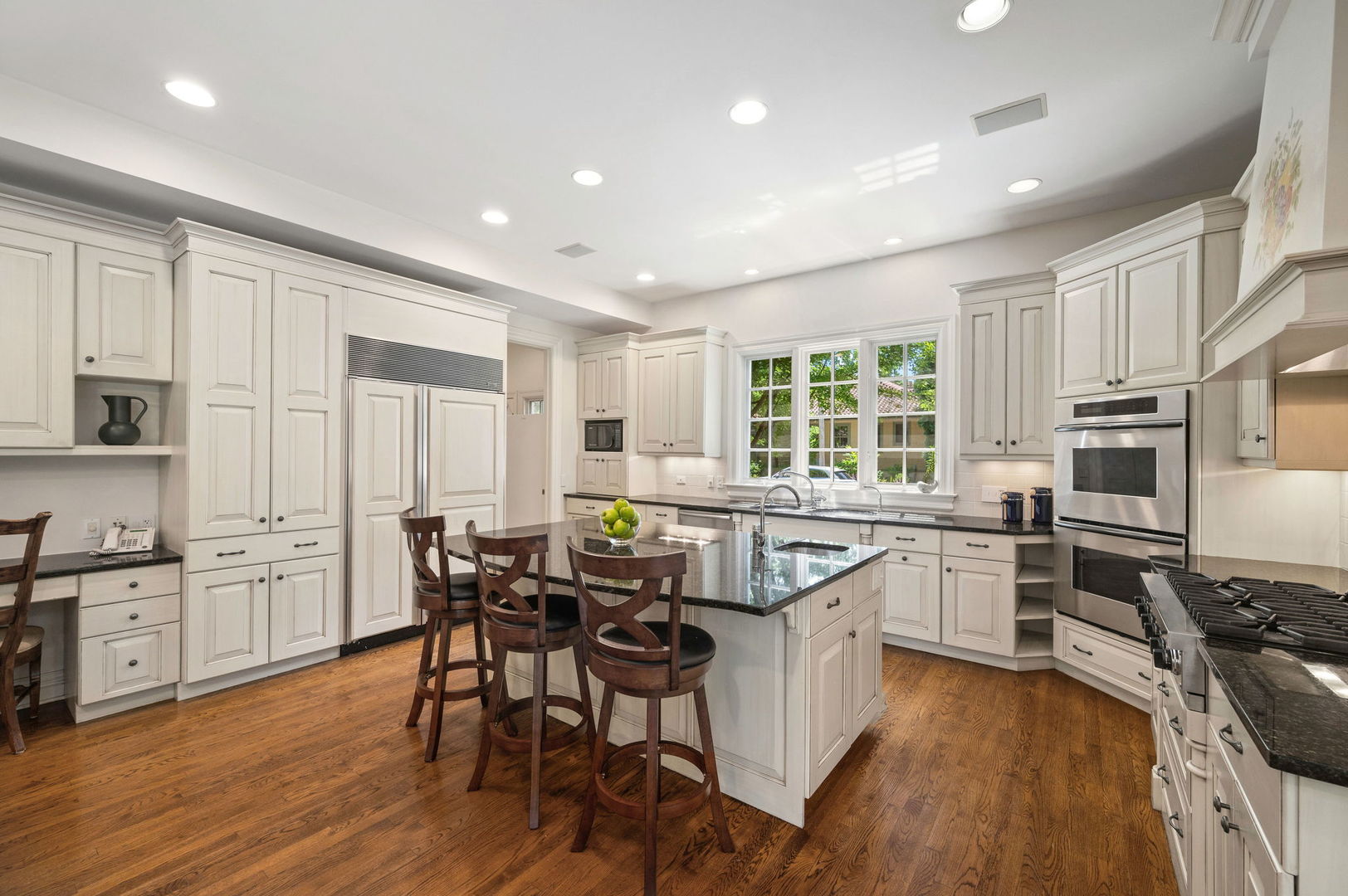 228 Old Green Bay Road Glencoe, IL 60093 - Photo 12 of 40 a kitchen with stainless steel appliances granite countertop wooden floors and white cabinets