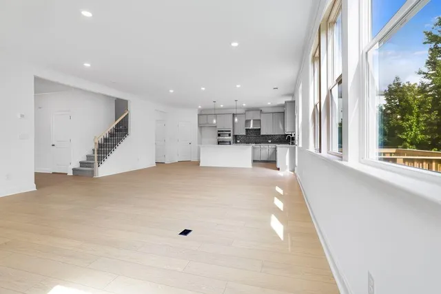 a view of a kitchen with kitchen island wooden floor and a living room