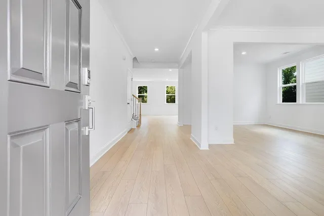 a view of a hallway with wooden floor and windows