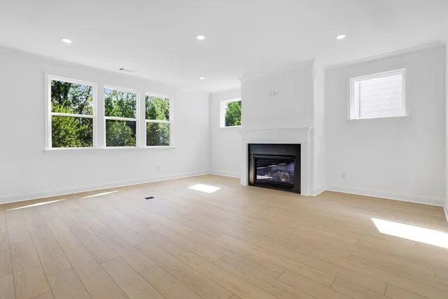an empty room with windows and fireplace