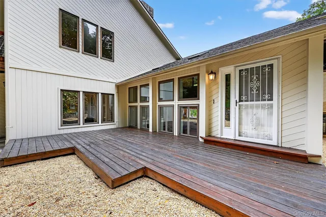 a view of a white house with many windows next to a yard