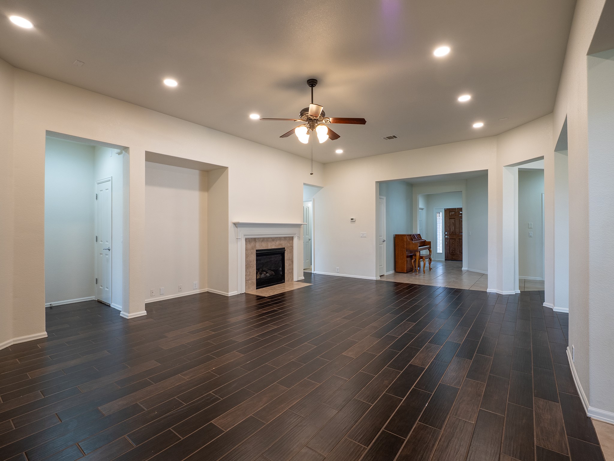 572 Big Meadow Road Austin, TX 78737 - Photo 3 of 32 Recessed lighting and dark wood flooring create a sleek, open living space, centered by a charming fireplace.