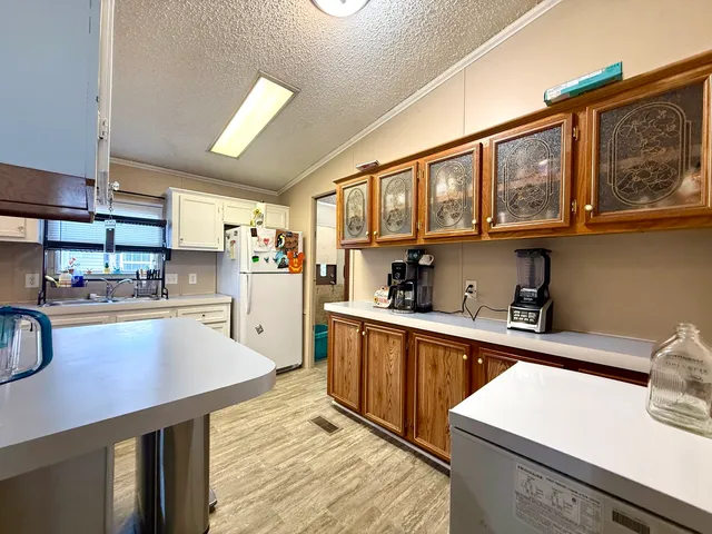 a kitchen with stainless steel appliances a sink dishwasher stove refrigerator and cabinets with wooden floor
