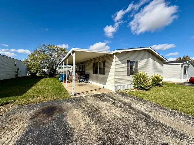 a view of a house with backyard and sitting area