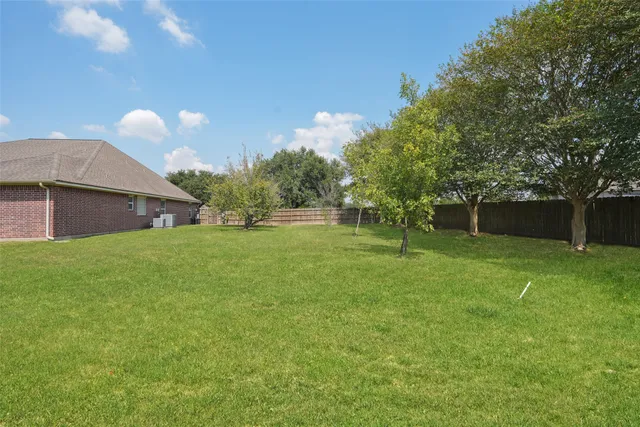 a front view of house with yard and trees in the background