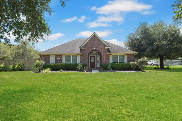 a front view of a house with a yard and trees