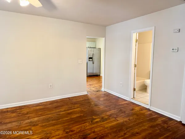 a view of an empty room with wooden floor