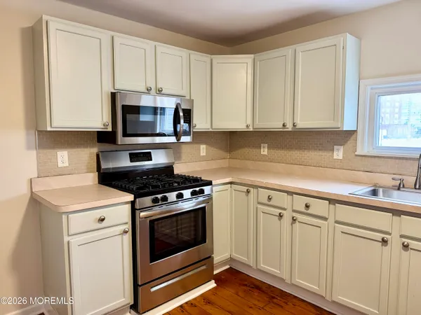 a kitchen with white cabinets and stainless steel appliances