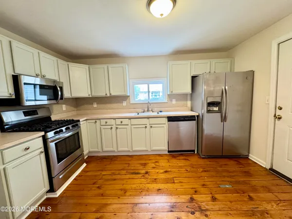 a kitchen with stainless steel appliances granite countertop a stove a sink dishwasher a refrigerator and a microwave