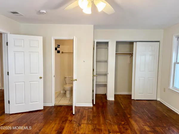 an empty room with wooden floor and closet area
