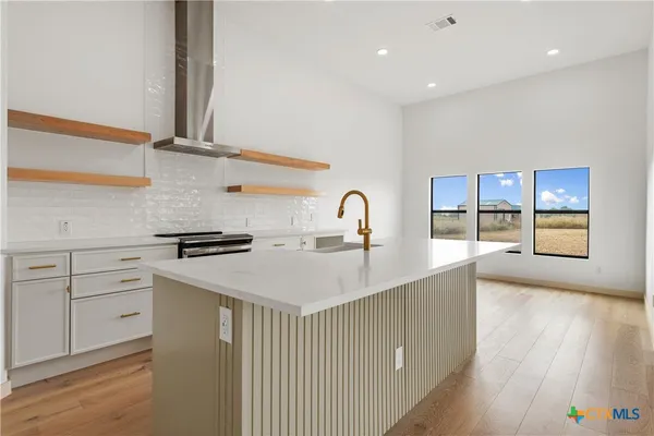 a kitchen with a sink a stove and cabinets