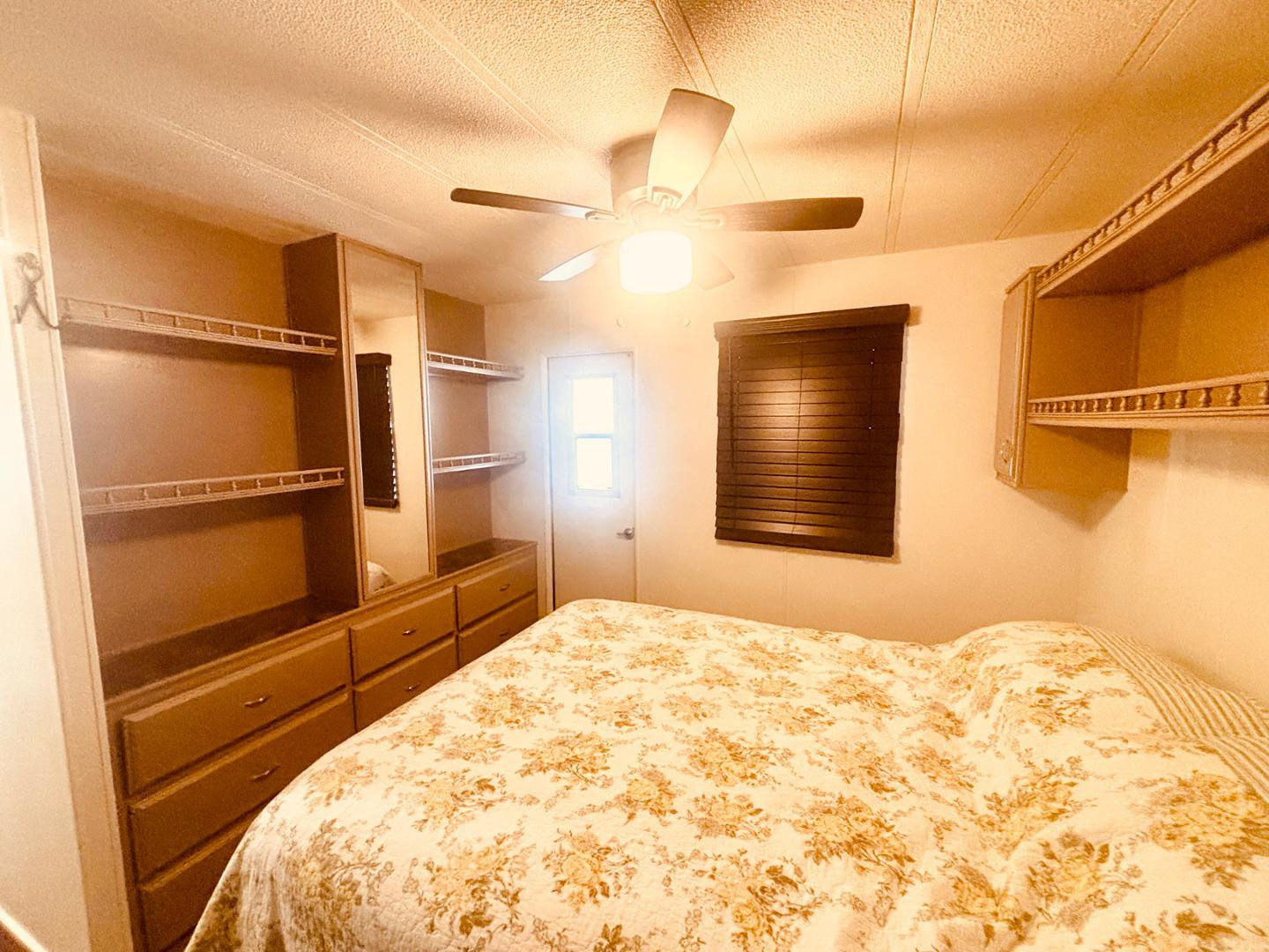 8865 East Baseline Road, Unit 405 Mesa, AZ 85209 - Photo 6 of 16 a bedroom with a bed and a chandelier