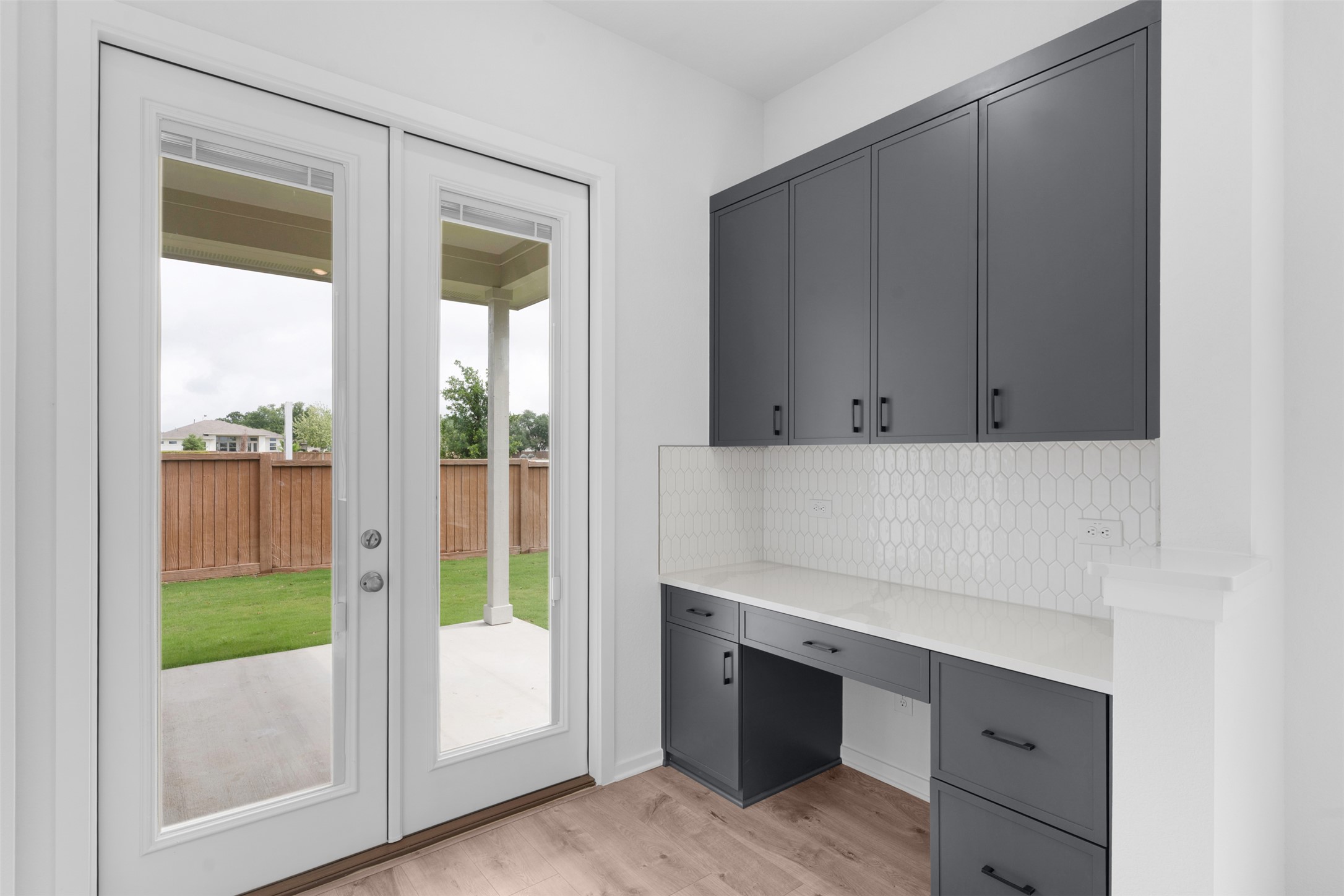 316 Ridgewell Loop Georgetown, TX 78633 - Photo 8 of 25 Home office space featuring dark gray cabinetry, white countertops, and a white geometric tile backsplash