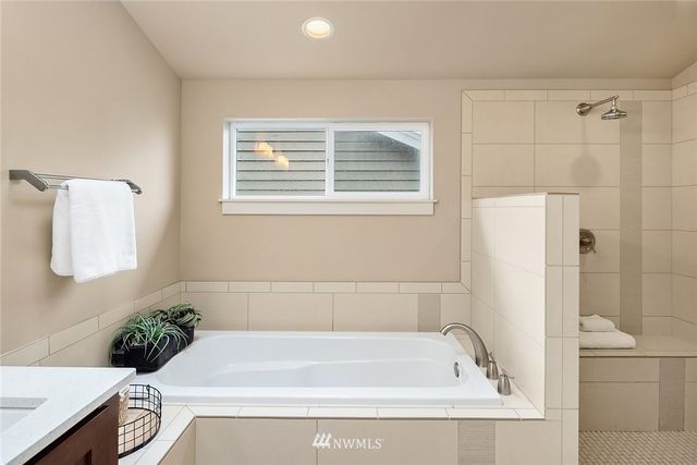 a bathroom with a tub a potted plant and a sink
