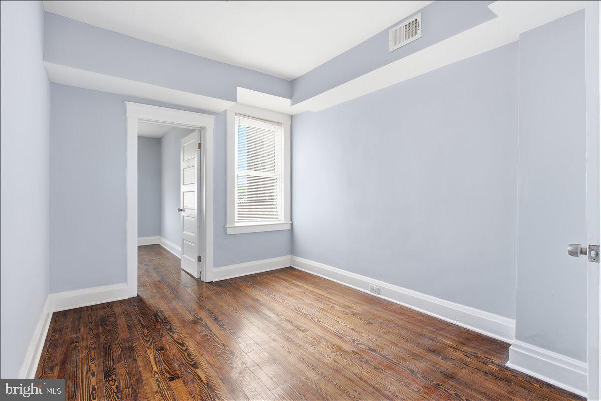 1231 North Potomac Street Baltimore, MD 21213 - Photo 14 of 25 an empty room with wooden floor and windows