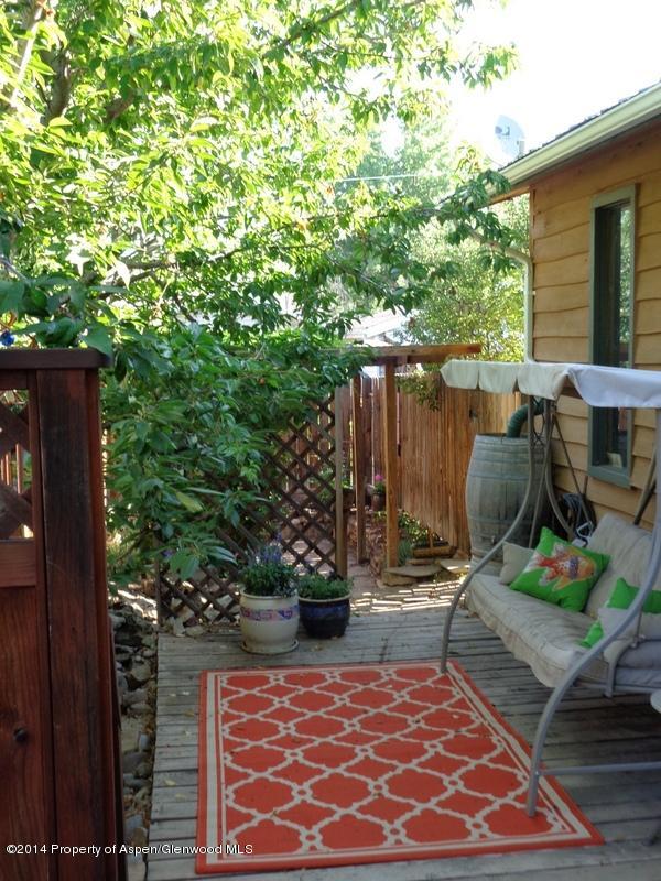 416 East 11th Street Rifle, CO 81650 - Photo 3 of 44 a view of a patio with table and chairs potted plants and wooden fence