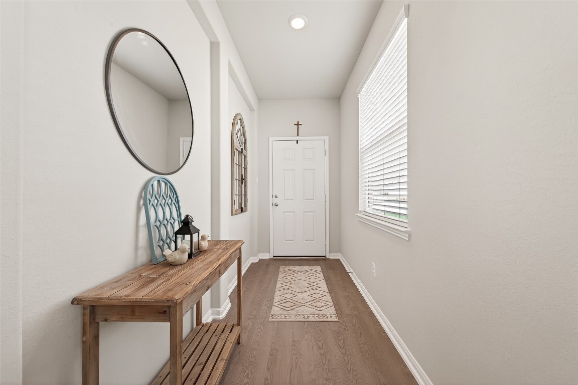 6027 Prince Place Drive Rosenberg, TX 77471 - Photo 4 of 39 Sunlight pours into the foyer from a large window, immediately showing off the warm wood-look floors.