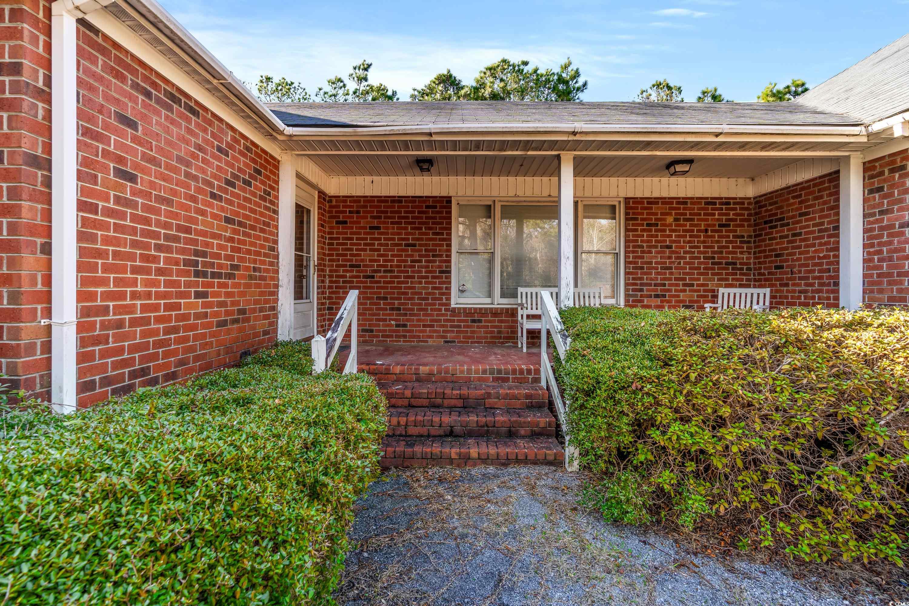 3673 South Island Road Georgetown, SC 29440 - Photo 5 of 26 Doorway to property featuring brick siding and a p