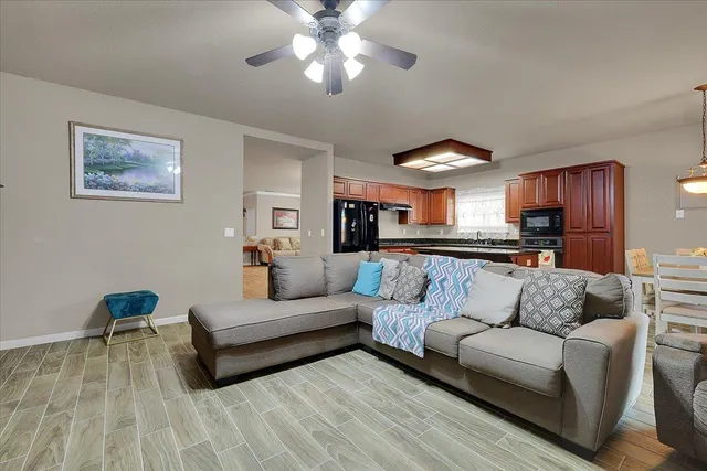 a living room with furniture and a view of kitchen