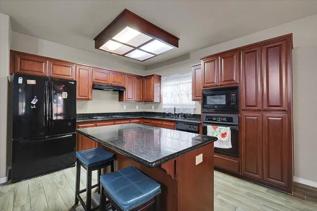 a kitchen with stainless steel appliances granite countertop a stove refrigerator sink and cabinets