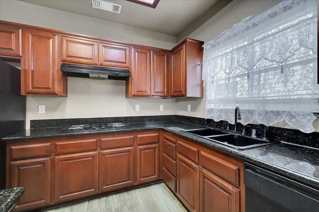 a kitchen with granite countertop a sink and cabinets