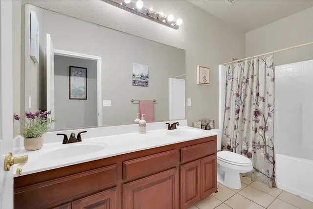 a bathroom with a double vanity sink toilet mirror and shower