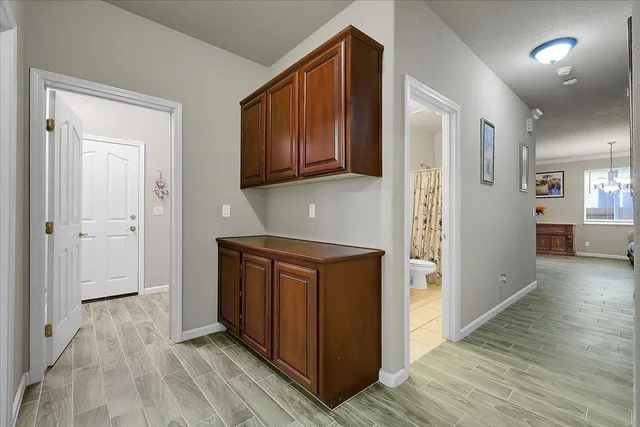 a hallway view with wooden floor and cabinets