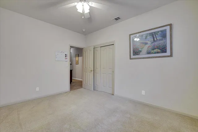 a view of an empty room with a chandelier fan