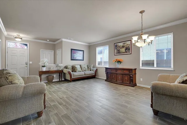 a living room with furniture chandelier and a window