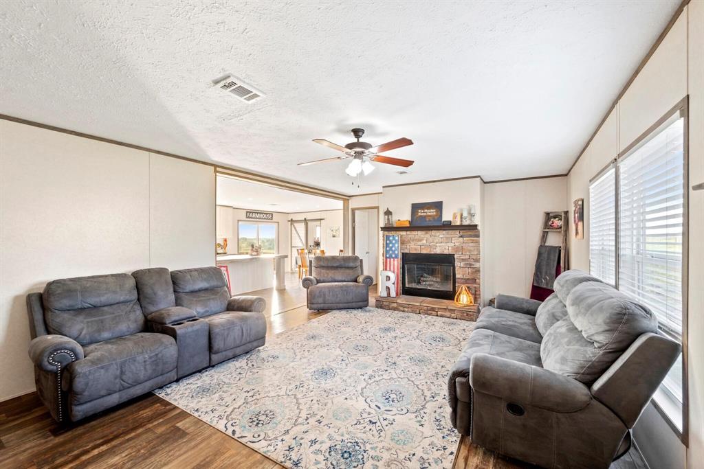 10026 County Rd NW 4350 Frost, TX 76641 - Photo 6 of 33 a living room with furniture a fireplace and a large window