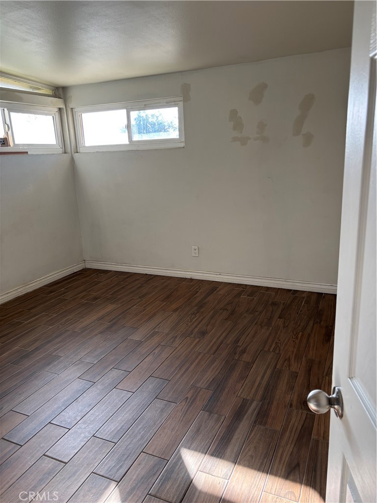 643 West Ramona Drive Rialto, CA 92376 - Photo 18 of 18 an empty room with wooden floor and windows