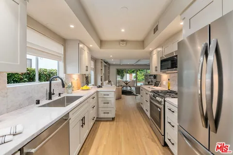 a kitchen with stainless steel appliances a sink stove and refrigerator