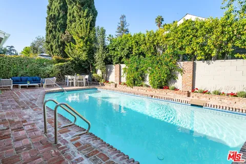 a view of a swimming pool with a patio and a garden
