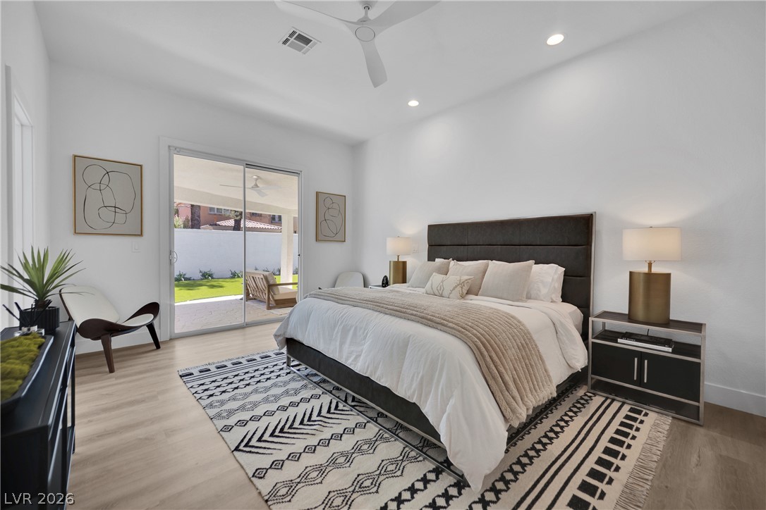 8981 Rivers Edge Drive Las Vegas, NV 89117 - Photo 32 of 69 Step into a serene bedroom offering outdoor access through sliding doors and elegant flooring.