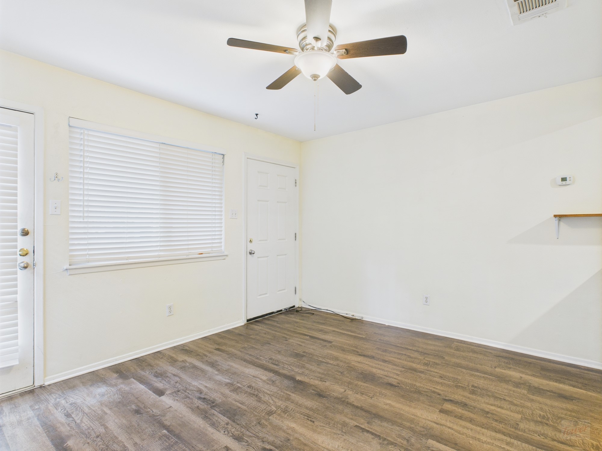 1106 West 22nd Street, Unit 5 Austin, TX 78705 - Photo 7 of 13 an empty room with wooden floor and windows